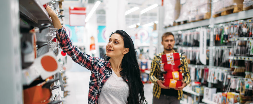 Young couple buying pans in supermarket